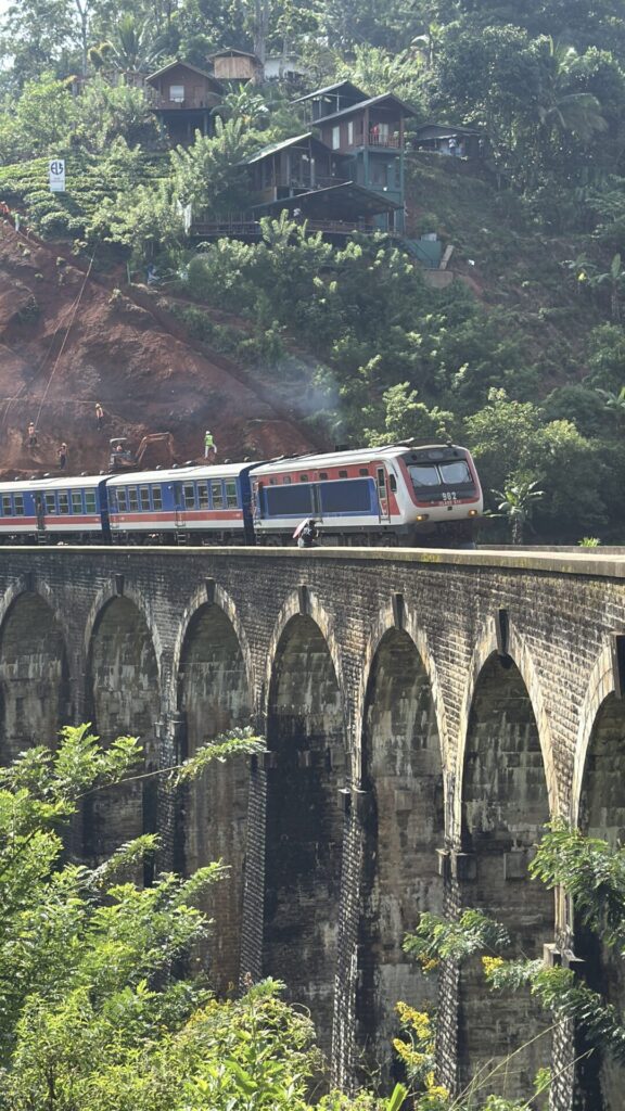 treno dal sapore vintage che passa su un ponte ad alte arcate in sri lanka