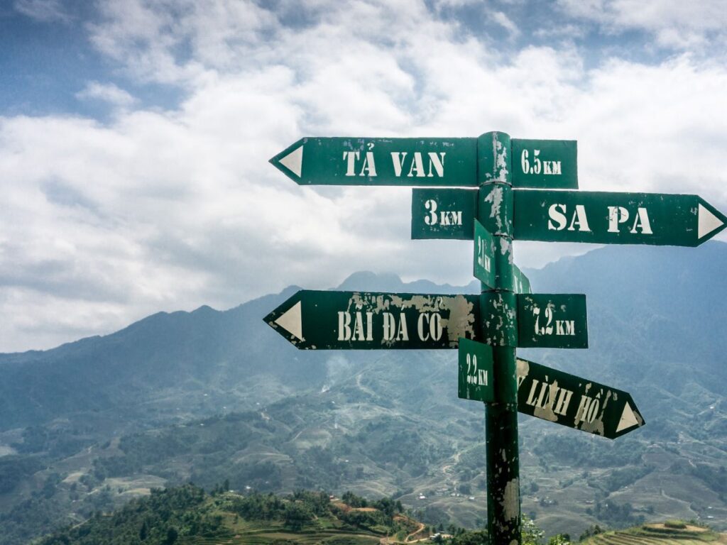 cartelli con indicazioni stradali su una strada di montagna durante un viaggio in Vietnam in moto
