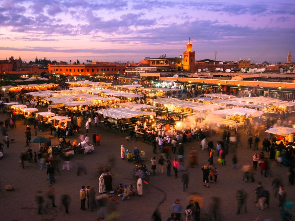 Prima volta in Marocco: vista dall'alto della piazza Jemaa el-Fna a Marrakech al crepuscolo, animata da bancarelle illuminate e persone.