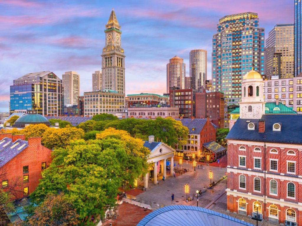 Vista dall'alto dello skyline di Boston al tramonto, con il celebre Faneuil Hall e la Custom House Tower circondati da alberi autunnali, da vedere nel New England viaggio di 12 giorni