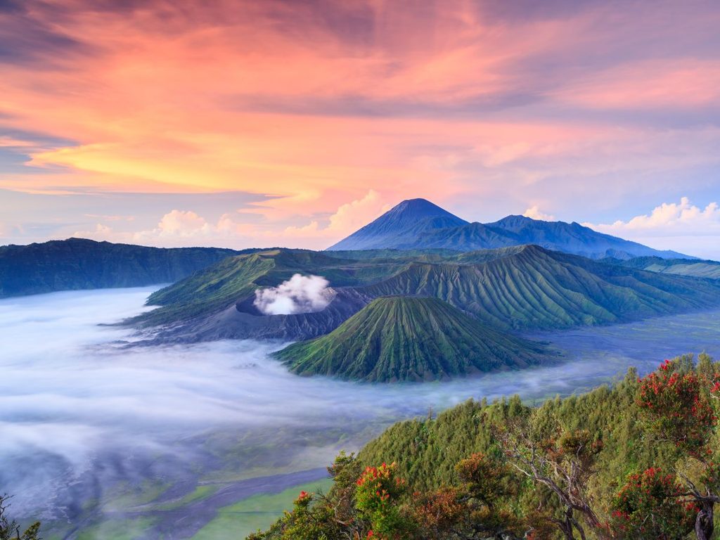 Panorama incantevole dei vulcani Bromo e Semeru illuminati dalla luce calda dell'alba a Giava.