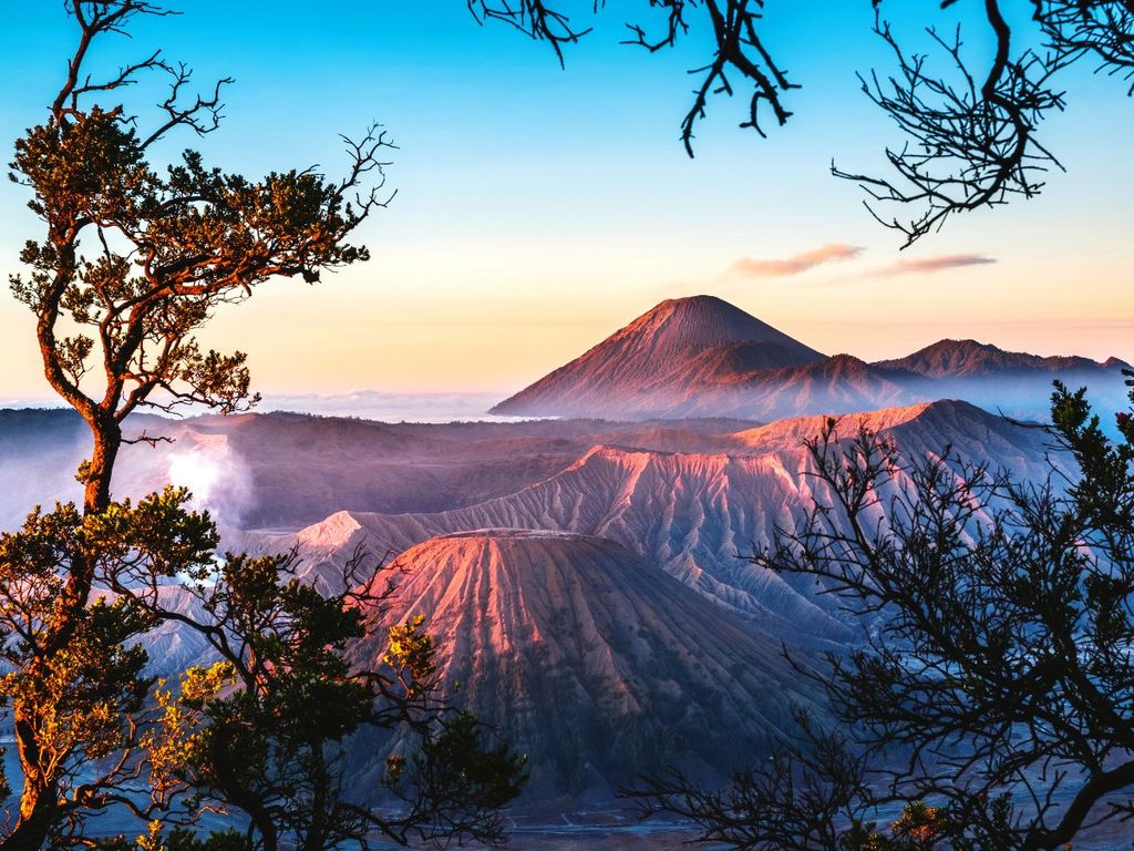 Panorama incantevole dei vulcani Bromo e Semeru illuminati dalla luce calda dell'alba a Giava.