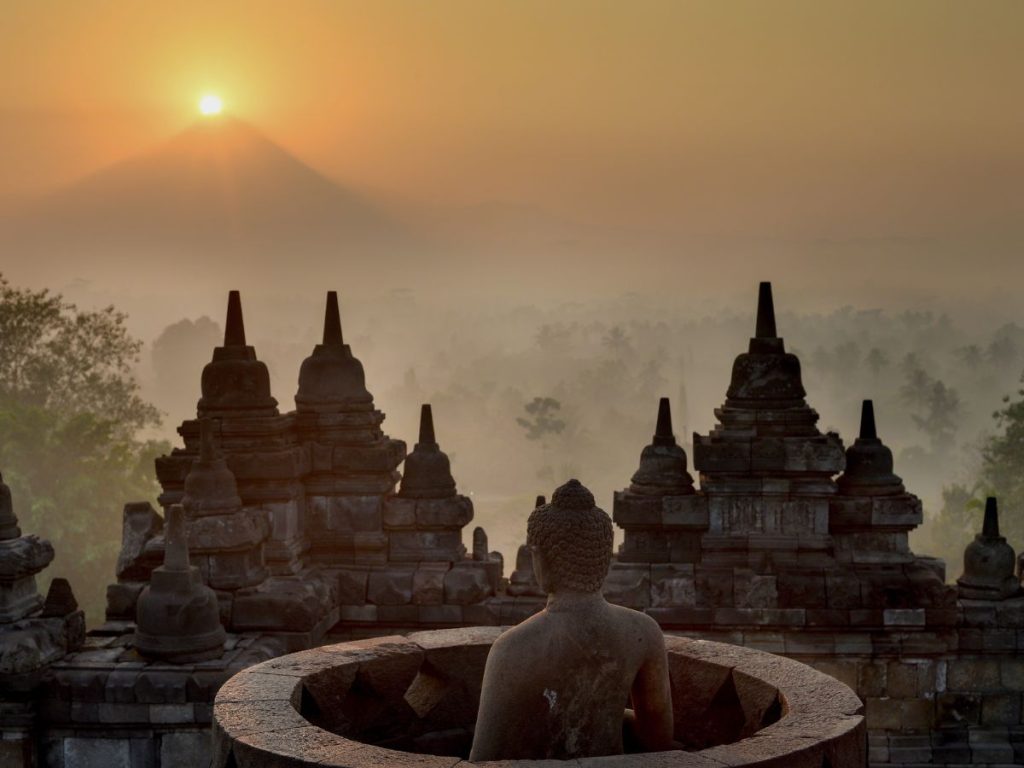 Alba a Borobudur, una delle esperienze sull’isola di Giava più suggestive: stupa e statua di Buddha tra la nebbia.