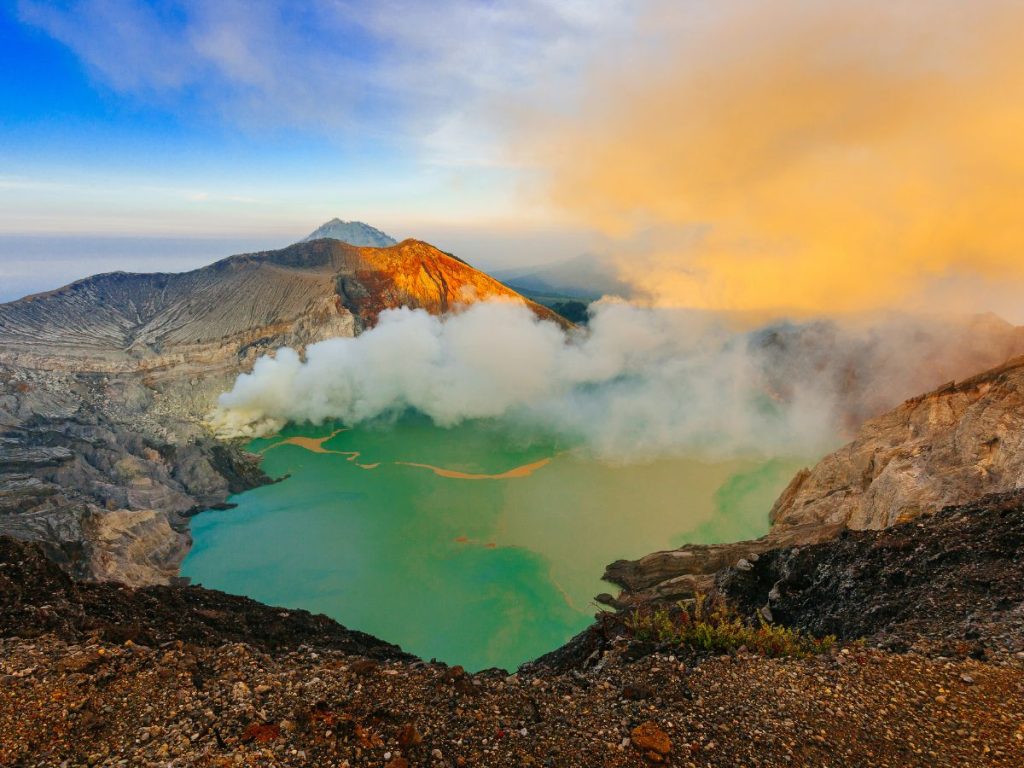 Il lago turchese del Kawah Ijen tra pareti vulcaniche e vapori di zolfo illuminati dalla luce del mattino